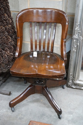 An early 20th century American walnut swivel desk chair by the Marble and Shattuck Chair Company, width 49cm, depth 44cm, height 86cm
